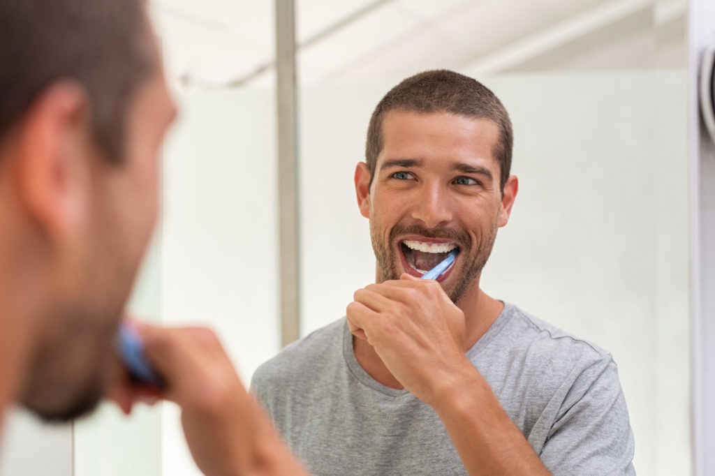 healthy habits for men, man brushing teeth