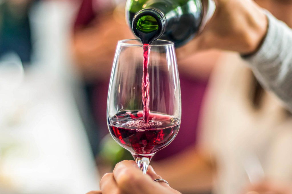pouring red wine into glass