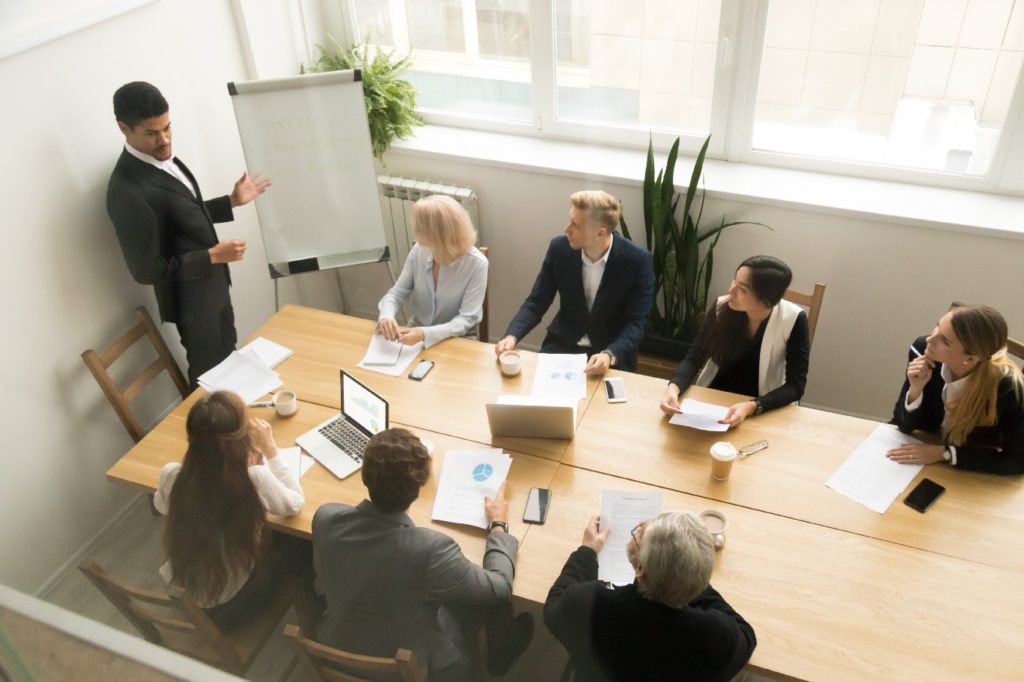 African american ceo giving presentation at corporate team meeting