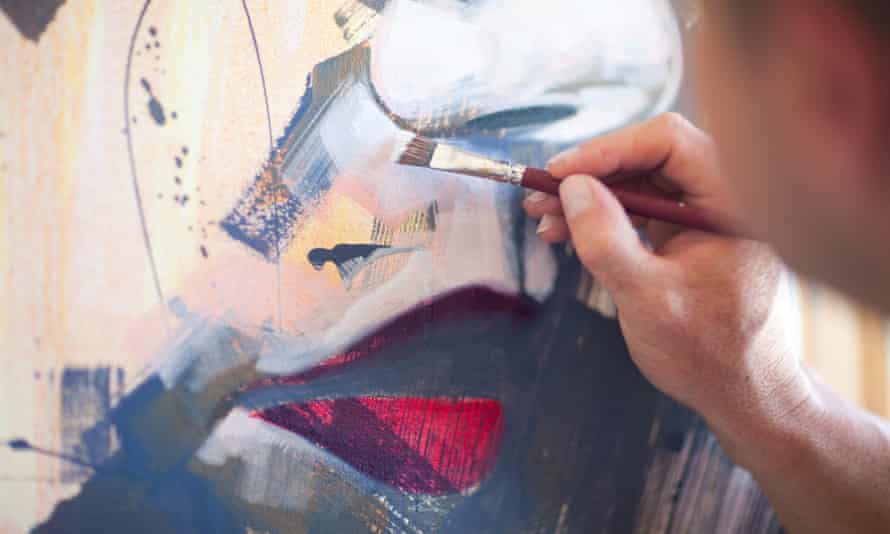 artist hand holding brush and painting picture