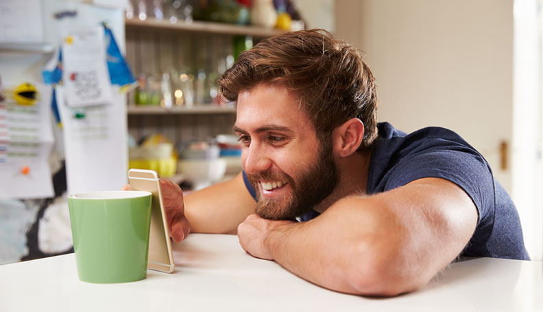 laughing man looking at cell phone