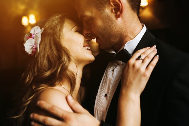 Newlyweds looking at each other's face and smiling 