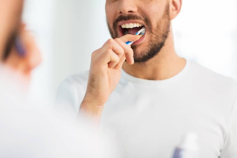 man brushing teeth