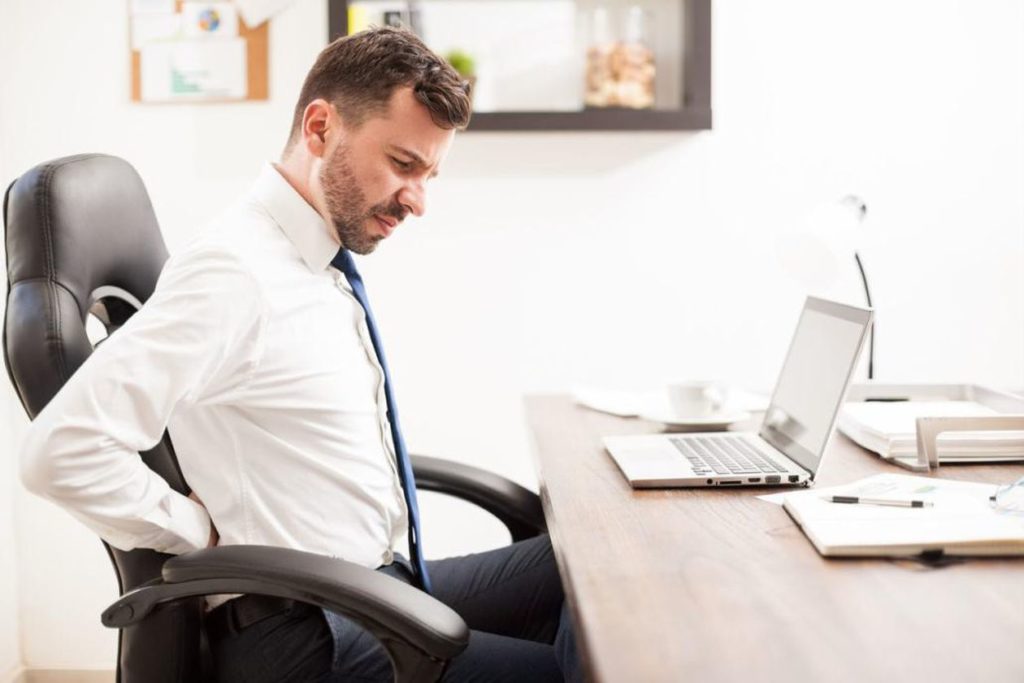 Man suffering from back pain while working