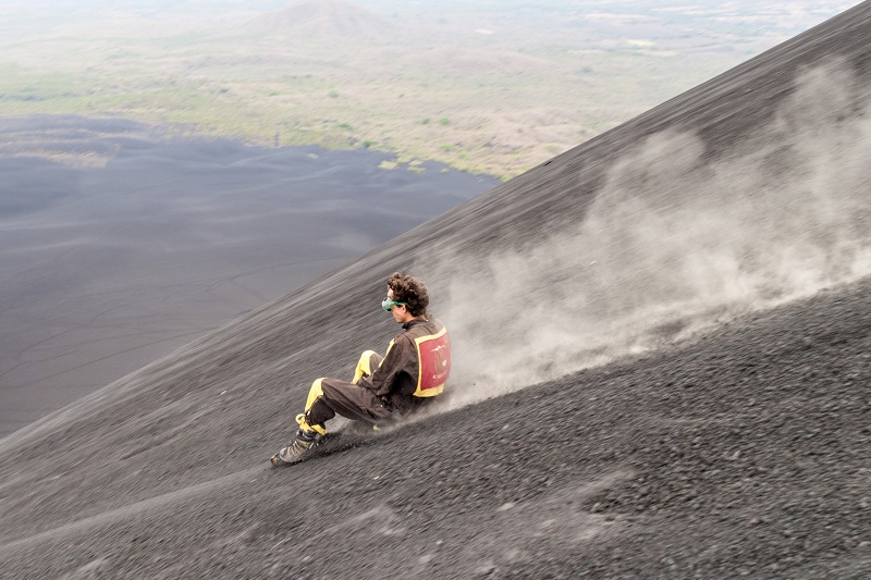 man enjoys vocano boarding extreme sports