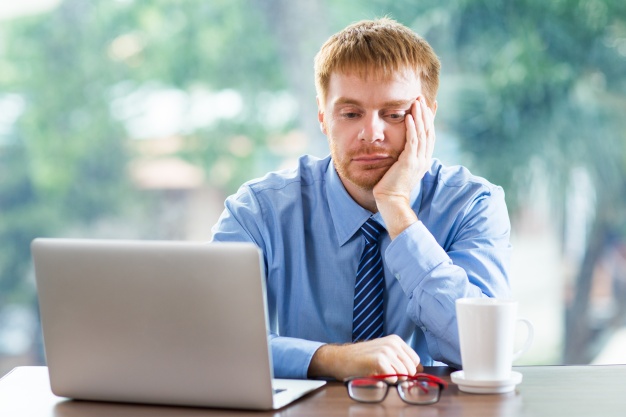 bored man looking at the laptop- bad habit for men