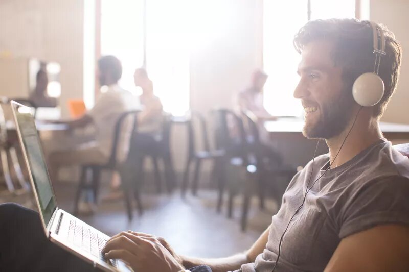 man using laptop and listening to music