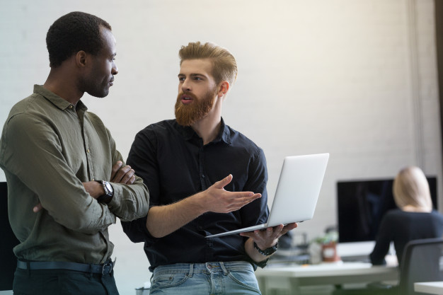 Two young smart business men discussing new project 