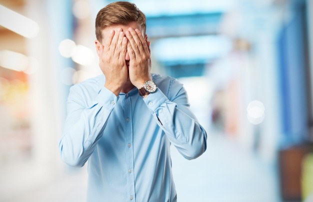 Man covering his eyes