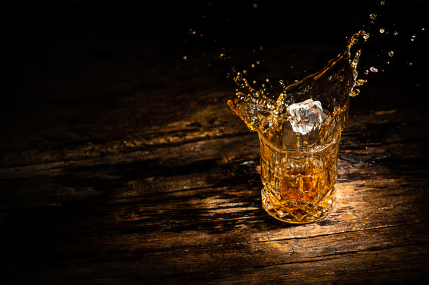 a glass of whisky with glass