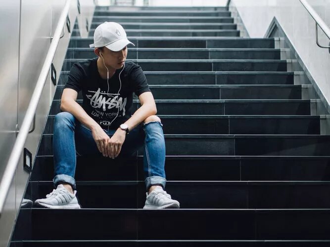 fashionable man sitting on staircase