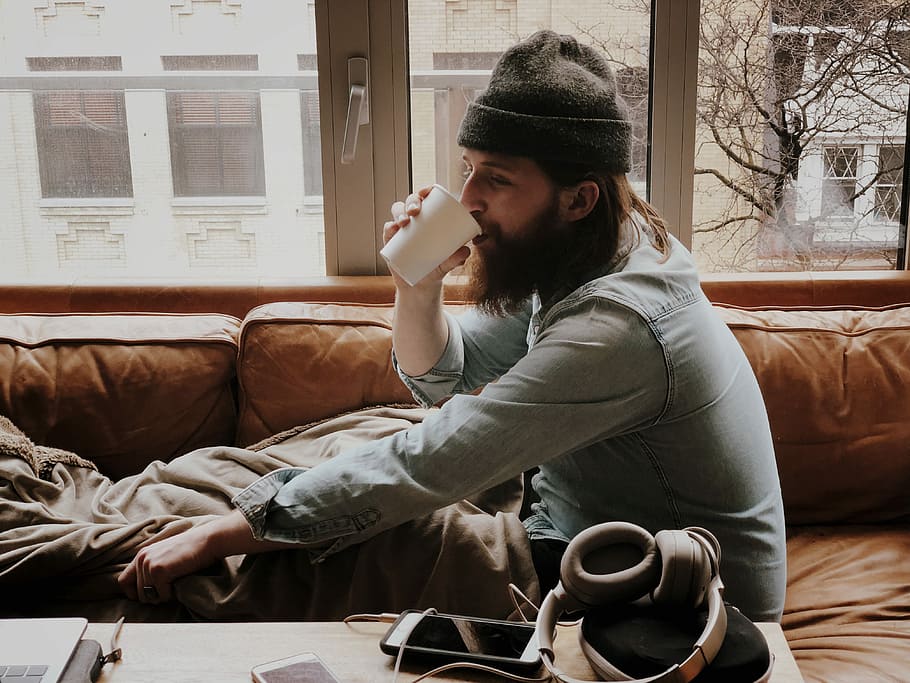 Young man drinking coffee on sofa