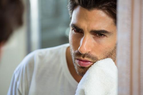 man scrub face with washcloth