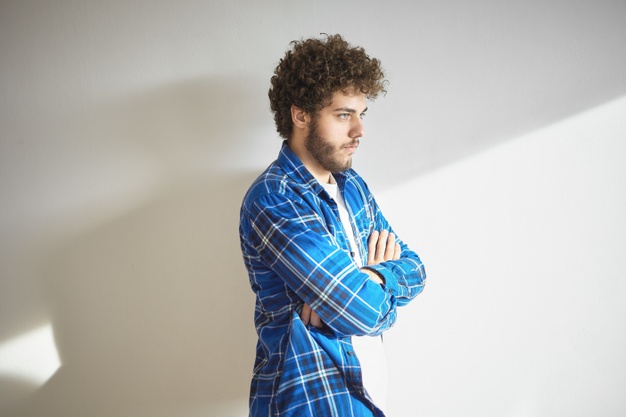 guy with fuzzy beard crossing arms on his chest as sign of disapproval