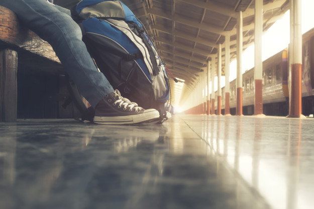 Traveler wearing backpack waiting for a train 