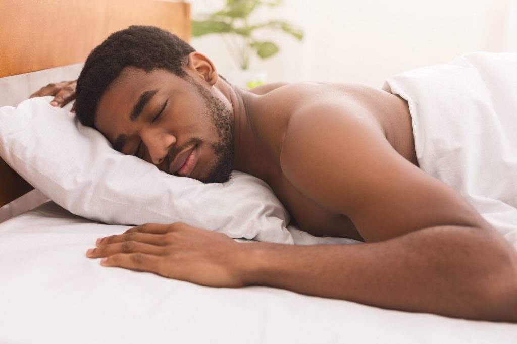 Man sleeping on bed in bedroom at home
