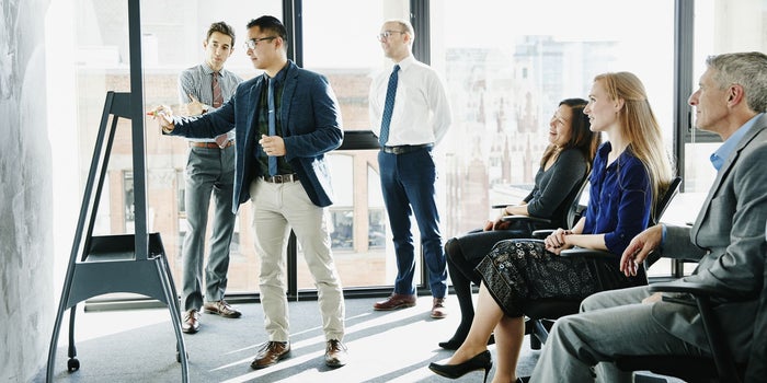  man presenting the successful ideas in front of Group Of Business people