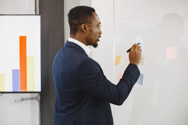 African man in a black suit. man writing on the glass