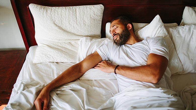 young man sleeping on bed