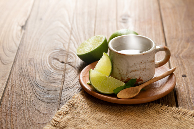 A cup of black tea with a lemon with cinnamon 