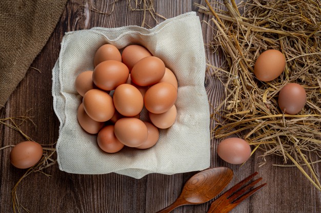 Eggs in cups on burlap with dry grass