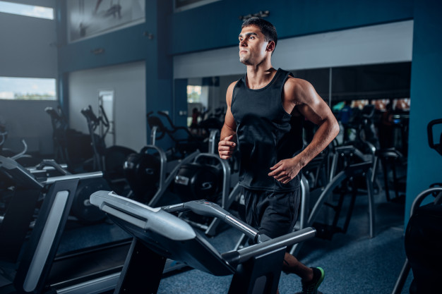 Male athlete workout on running exercise machine. active sport training in gym