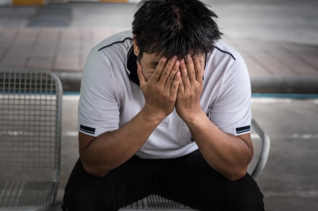Man fired from job sitting sad outside office 