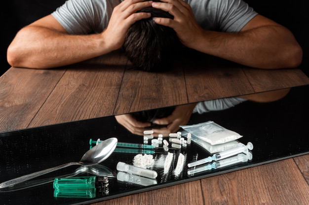 man reaches for drugs. the fight against drug addiction