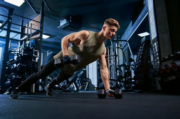 Muscular man doing push ups on one hand