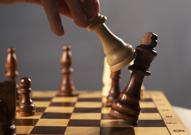Queen beating king on chessboard Premium 