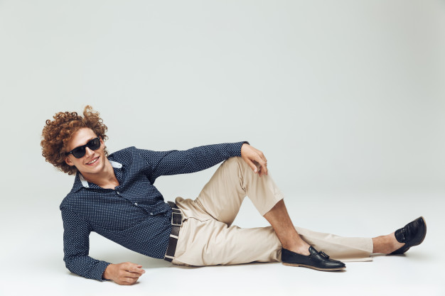 Retro man dressed in shirt lies on floor and posing