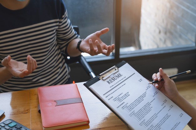 businesswoman-reading-resume-man-document-during-interview