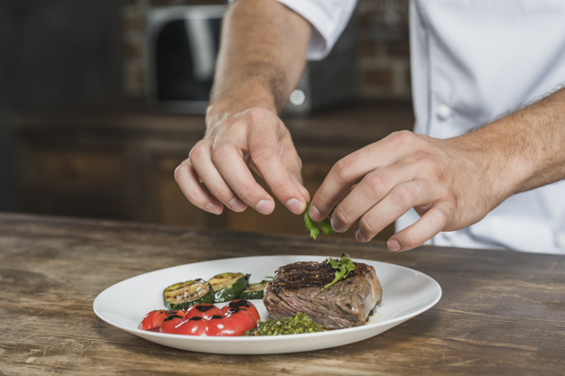close-up-male-chef-decorating-dish
