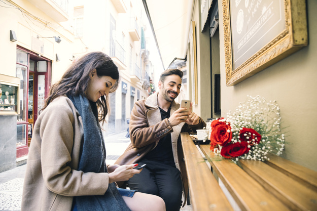 Couple browsing smartphones on date