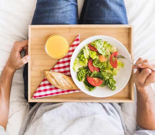 man eating healthy food on bed