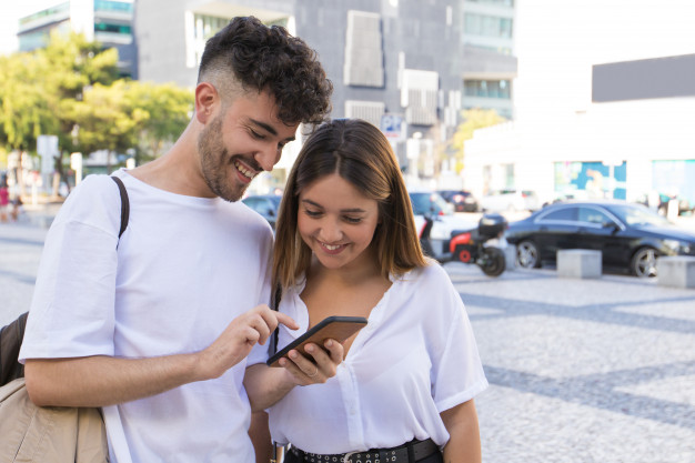 Happy couple watching video on cell 
