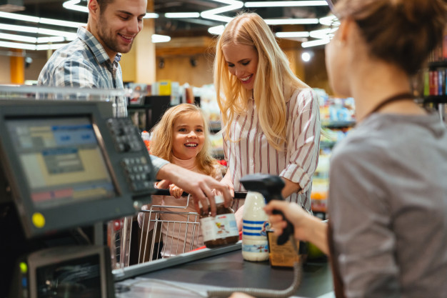 Happy family standing at the cash counter