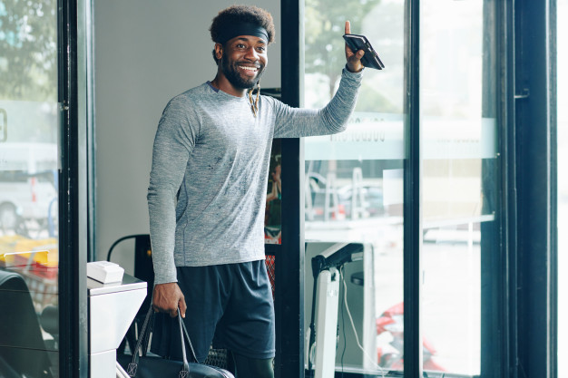Happy fit man leaving gym