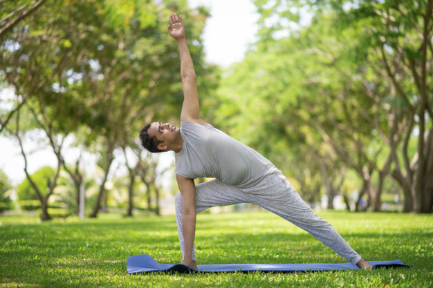 Inspired Indian man doing yoga asanas in city park