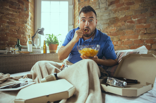 stressed man eating; unhealthy lifestyle
