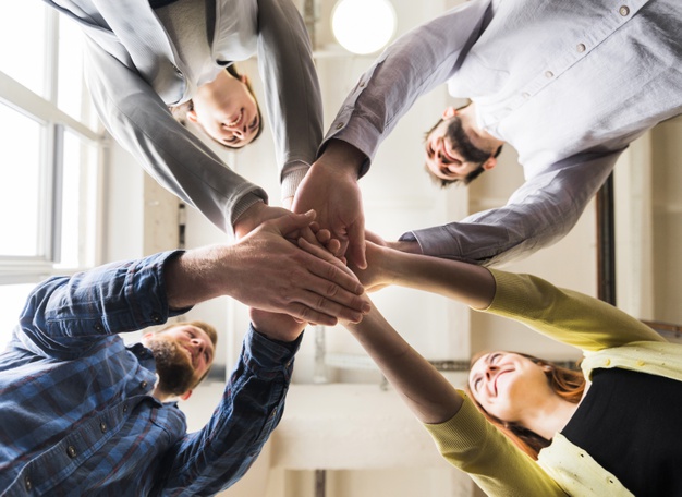 low-angle-view-businesspeople-stacking-hand-together-workplace