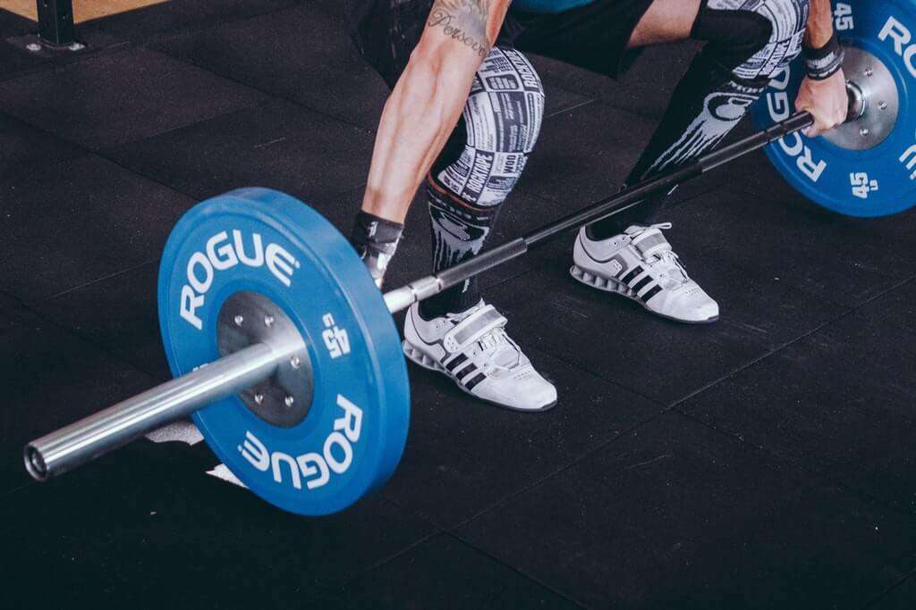 man-doing-workout-with-Rogue-Fitness-olympic-barbell