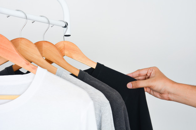 man-s-hand-choosing-black-color-t-shirt-from-collection-black-gray-white-t-shirt-wooden-hanger
