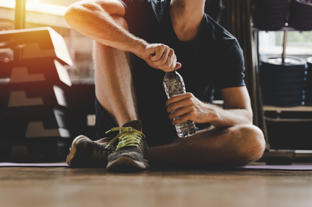 man drinking water during workout