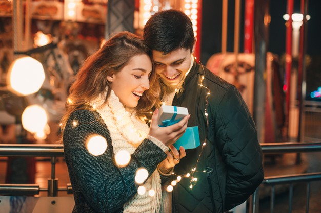 Romantic surprise for christmas, woman receives a gift from her boyfriend