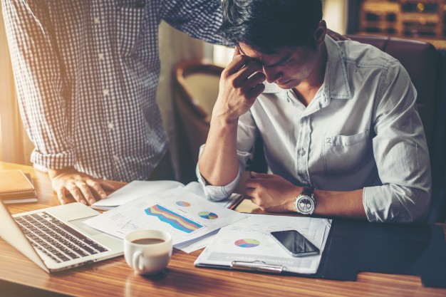 Serious young businessman looking at financial report seem like