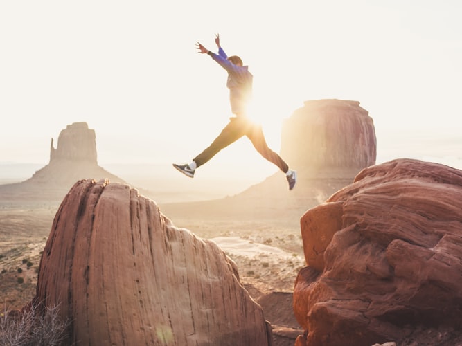 man jumping from cliff