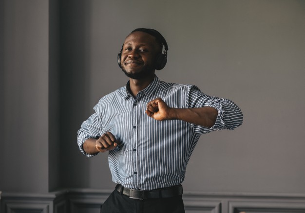 man in stylish shirt in headphones listening music and enjoying music