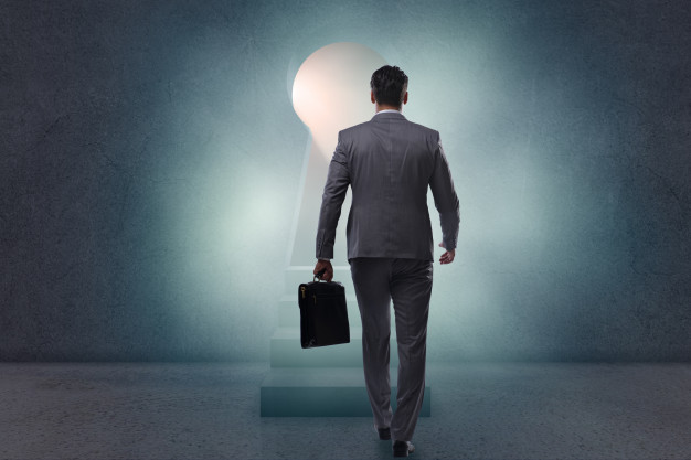 businessman-walking-towards-light-from-keyhole