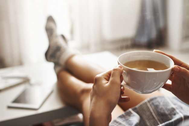 holding-legs-coffee-table-drinking-hot-coffee
